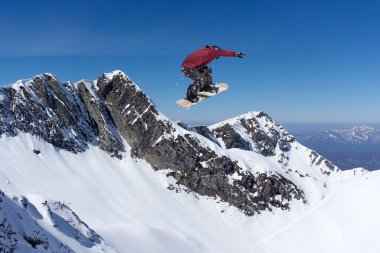 Dağlarda uçan snowboardcu. Sıra dışı spor.