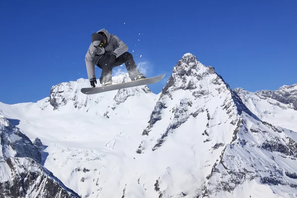 Ιπτάμενος snowboarder στα βουνά. Ακραίο άθλημα. — Φωτογραφία Αρχείου