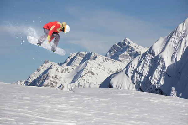 Um snowboarder voador nas montanhas. Desporto extremo. — Fotografia de Stock