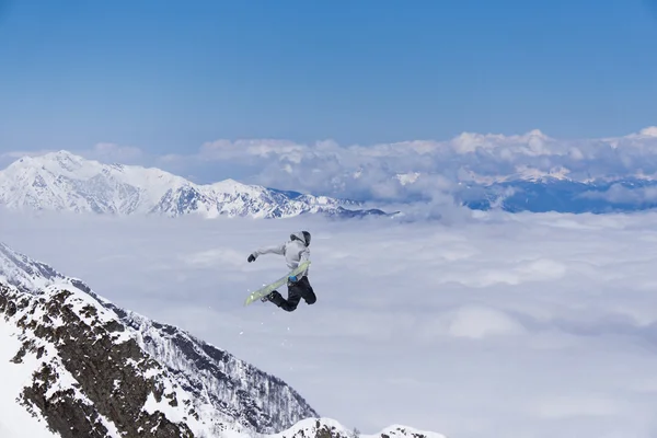 Um snowboarder voador nas montanhas. Desporto extremo. — Fotografia de Stock