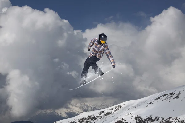 Um snowboarder voador nas montanhas. Desporto extremo. — Fotografia de Stock