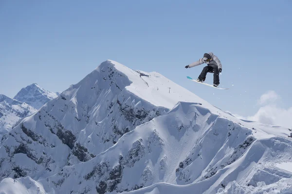 Um snowboarder voador nas montanhas. Desporto extremo. — Fotografia de Stock