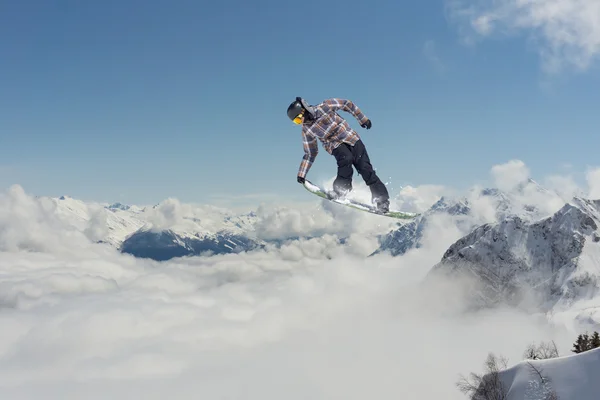 Fliegender Snowboarder auf den Bergen. Extremsport. — Stockfoto