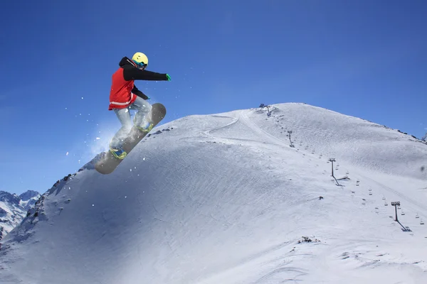 Létající snowboardista na horách. Extrémní sport. — Stock fotografie