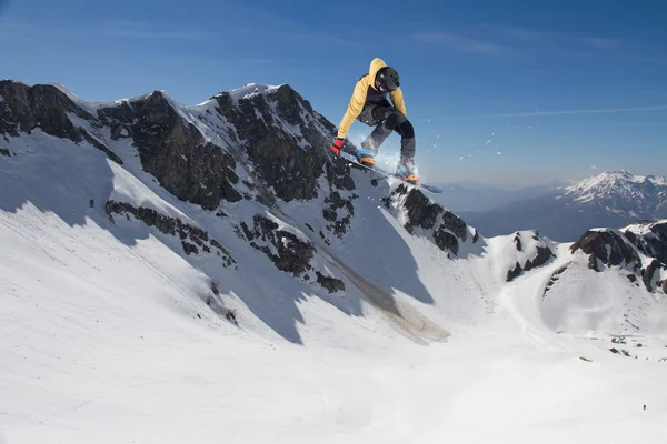 Fliegender Snowboarder auf den Bergen. Extremsport. — Stockfoto