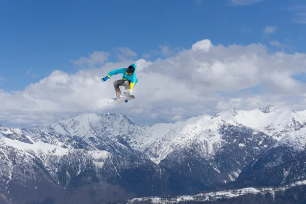 Flygande snowboardåkare på fjället. Extrem sport. — Stockfoto