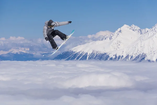 Repülő snowboardos a hegyekben. Extrém sport. — Stock Fotó