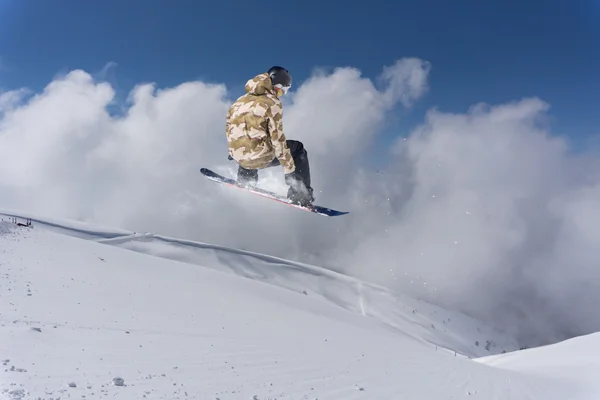 Um snowboarder voador nas montanhas. Desporto extremo. — Fotografia de Stock