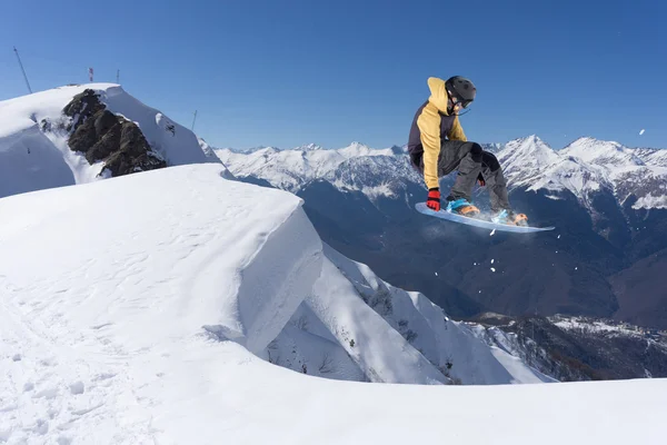 Um snowboarder voador nas montanhas. Desporto extremo. — Fotografia de Stock