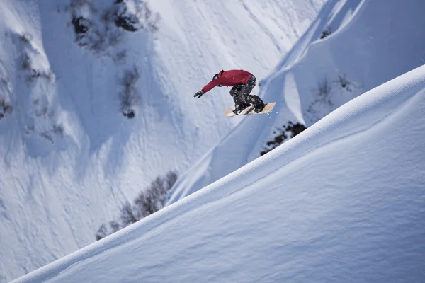 Flygande snowboardåkare på fjället. Extrem sport. — Stockfoto