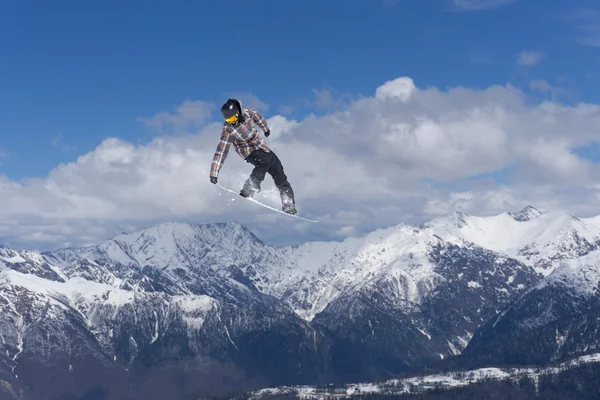 Um snowboarder voador nas montanhas. Desporto extremo. — Fotografia de Stock