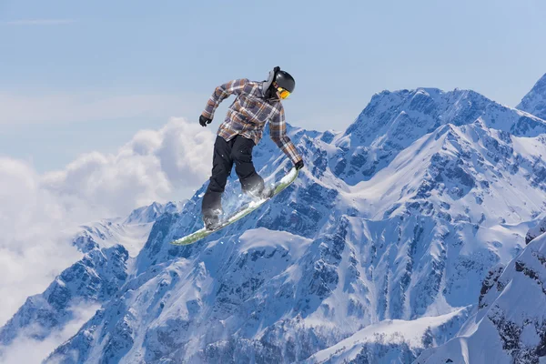 Repülő snowboardos a hegyekben. Extrém sport. — Stock Fotó