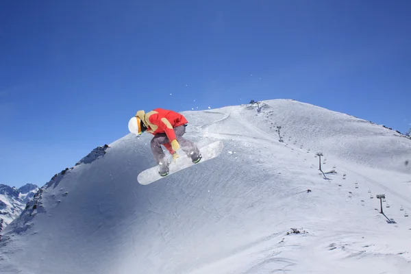 Vliegende snowboarder op de bergen. Extreme sport. — Stockfoto