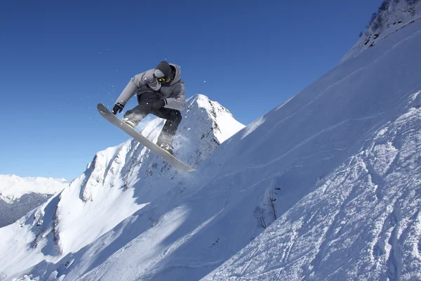 Vliegende snowboarder op de bergen. Extreme sport. — Stockfoto