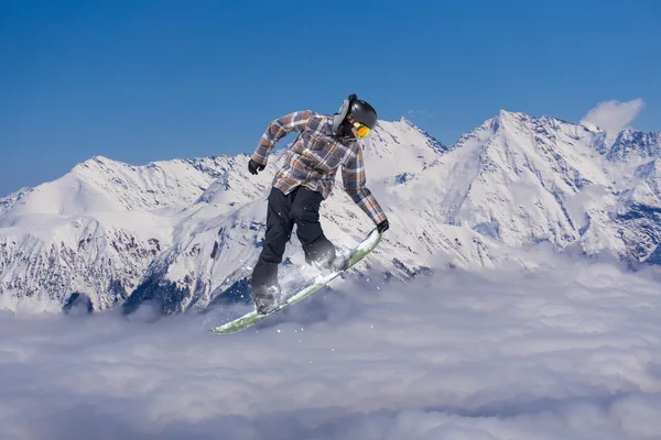 Flygande snowboardåkare på fjället. Extrem sport. — Stockfoto