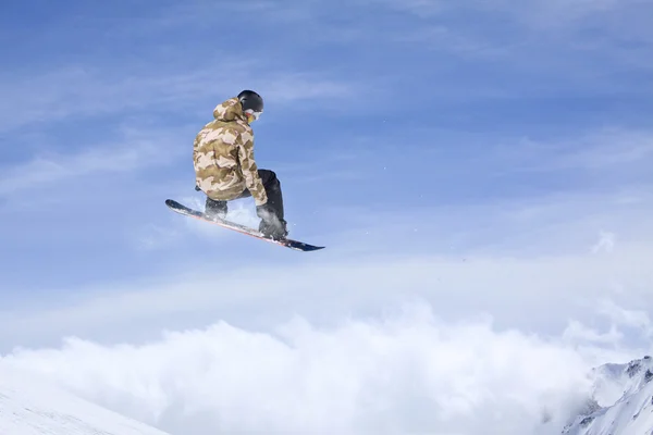 Um snowboarder voador nas montanhas. Desporto extremo. — Fotografia de Stock