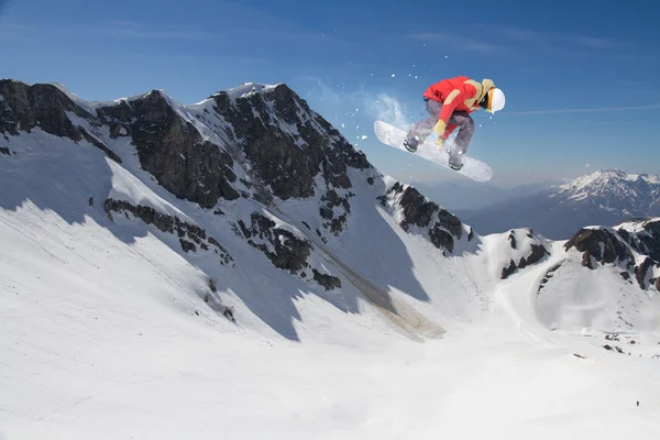 Flygande snowboardåkare på fjället. Extrem sport. — Stockfoto