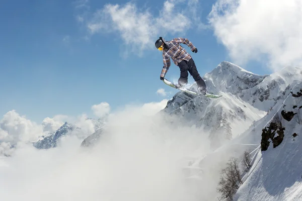 Repülő snowboardos a hegyekben. Extrém sport. — Stock Fotó