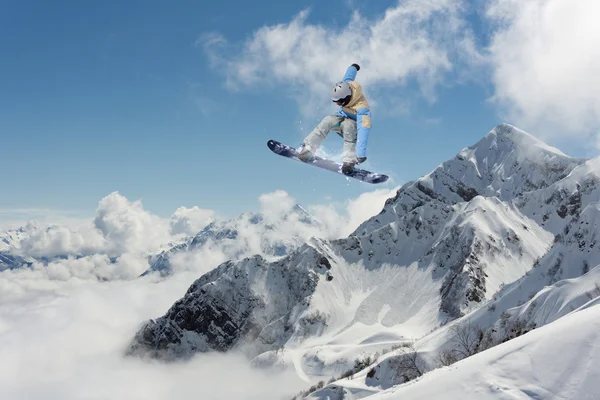 Fliegender Snowboarder auf den Bergen. Extremsport. — Stockfoto