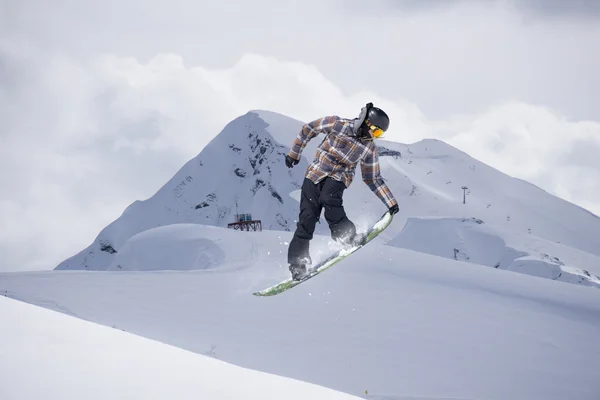 Fliegender Snowboarder auf den Bergen. Extremsport. — Stockfoto