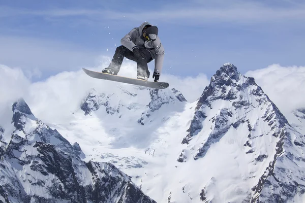 Um snowboarder voador nas montanhas. Desporto extremo. — Fotografia de Stock