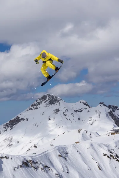 Flygande snowboardåkare på fjället. Extrem sport. — Stockfoto