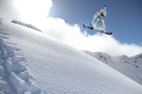 Repülő snowboardos a hegyekben. Extrém sport. — Stock Fotó