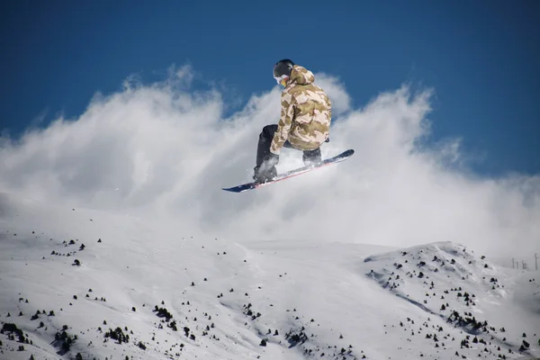 Um snowboarder voador nas montanhas. Desporto extremo. — Fotografia de Stock