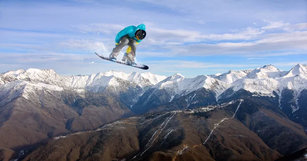 Um snowboarder voador nas montanhas. Desporto extremo. — Fotografia de Stock