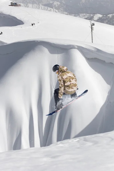 Um snowboarder voador nas montanhas. Desporto extremo. — Fotografia de Stock