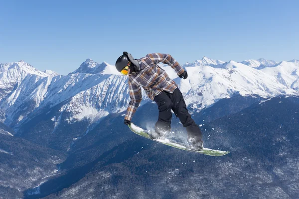 Vliegende snowboarder op de bergen. Extreme sport. — Stockfoto