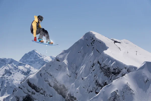 Vliegende snowboarder op de bergen. Extreme sport. — Stockfoto