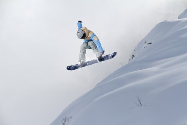 Dağlarda uçan snowboardcu. Sıra dışı spor.