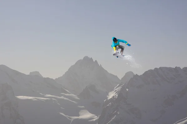 Vliegende snowboarder op de bergen. Extreme sport. — Stockfoto