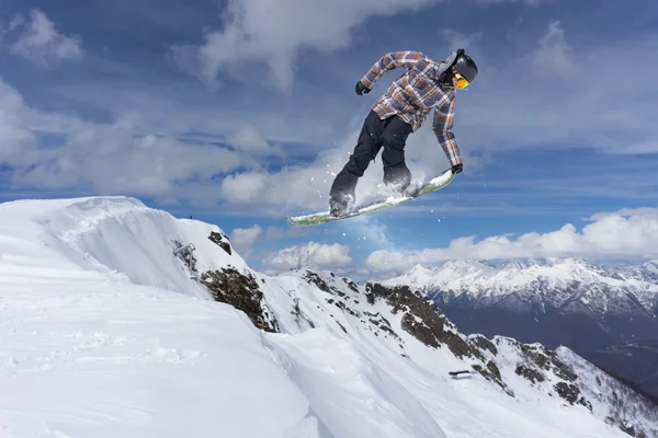 Flygande snowboardåkare på fjället. Extrem sport. — Stockfoto