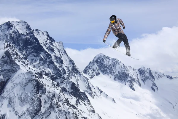 Flygande snowboardåkare på fjället. Extrem sport. — Stockfoto