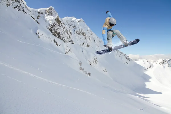 Flygande snowboardåkare på fjället. Extrem sport. — Stockfoto