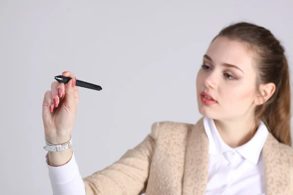 Ung kvinna med penna på grå bakgrund — Stockfoto