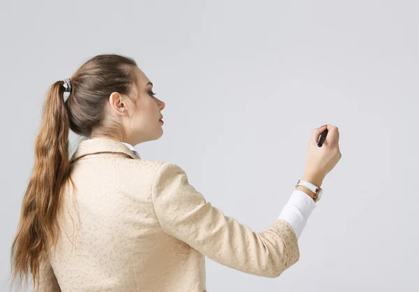 Young woman with pen on grey background — Stock Photo, Image