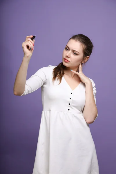 Jonge vrouw met pen op een grijze achtergrond — Stockfoto