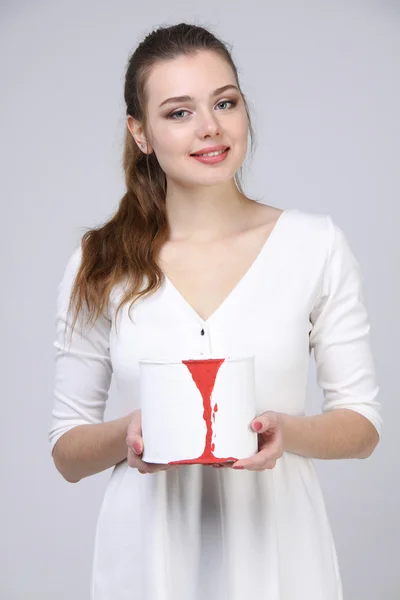 Chica en vestido blanco sosteniendo pintura lata — Foto de Stock