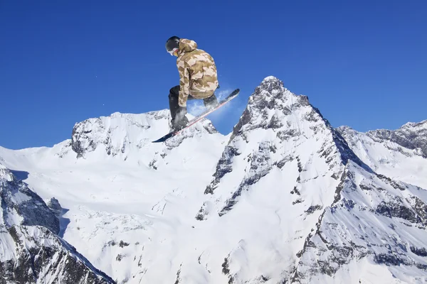 Vliegende snowboarder op de bergen. Extreme sport. — Stockfoto