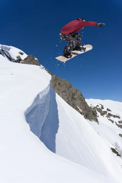 Ιπτάμενος snowboarder στα βουνά. Ακραίο άθλημα. — Φωτογραφία Αρχείου