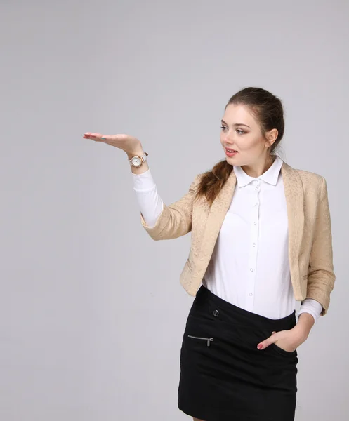 Sonriente joven mujer de negocios mostrando área en blanco — Foto de Stock