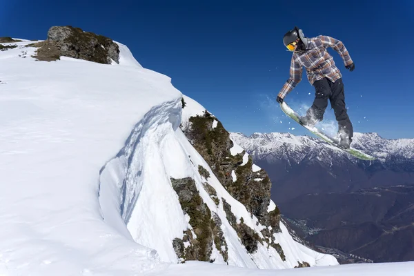 Flygande snowboardåkare på fjället. Extrem sport. Stockfoto