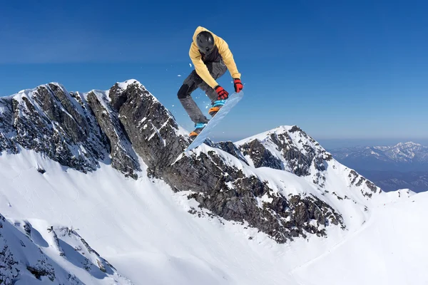 Volando snowboarder en las montañas. Deporte extremo. — Foto de Stock