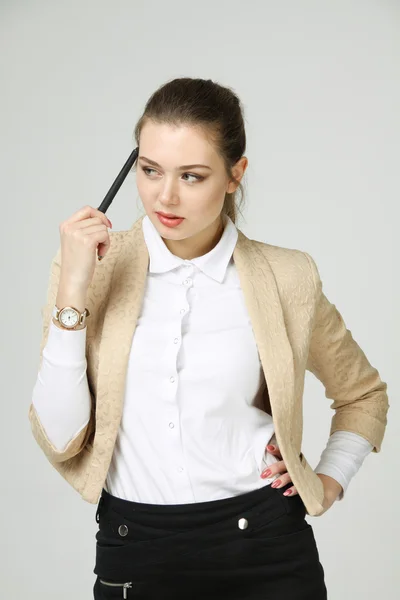 Młody biznes kobieta myśli, w ręku trzyma długopis — Zdjęcie stockowe