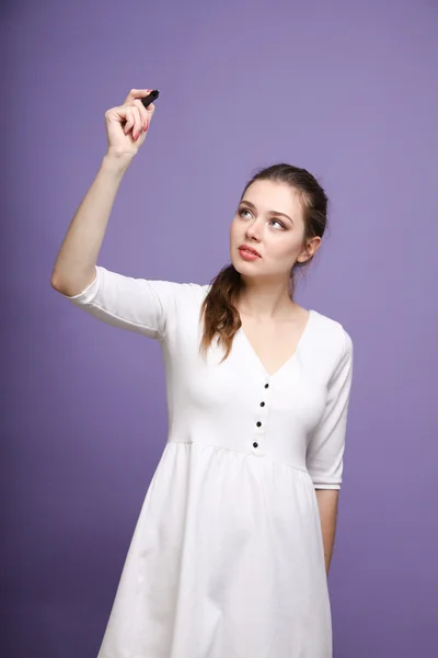 Mujer joven con pluma sobre fondo gris —  Fotos de Stock