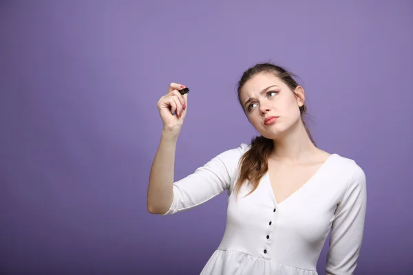 Jovem mulher com caneta sobre fundo cinza — Fotografia de Stock