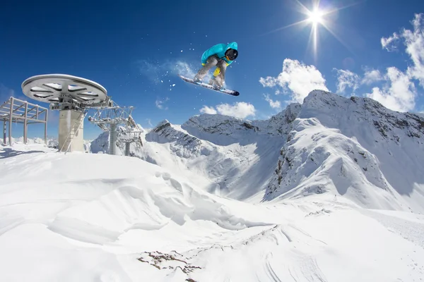 Flygande snowboardåkare på fjället. Extrem sport. — Stockfoto